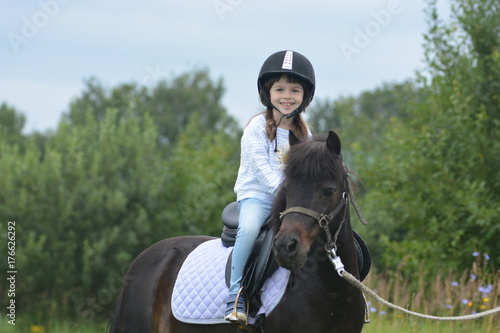 Little girl riding a pony
