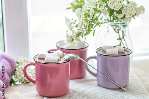 Marshmallows on top of hot cocoa in pink cups