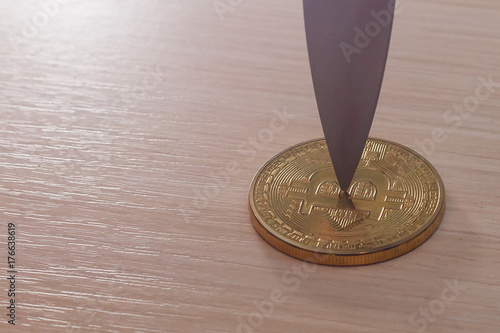 Blade of a knife on a gold coin bitcoin photo