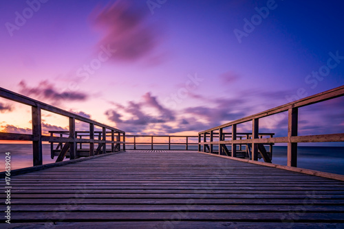 Fototapeta Naklejka Na Ścianę i Meble -  Wooden pier on the sea beach at sunset