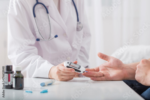 doctor measuring blood sugar young men