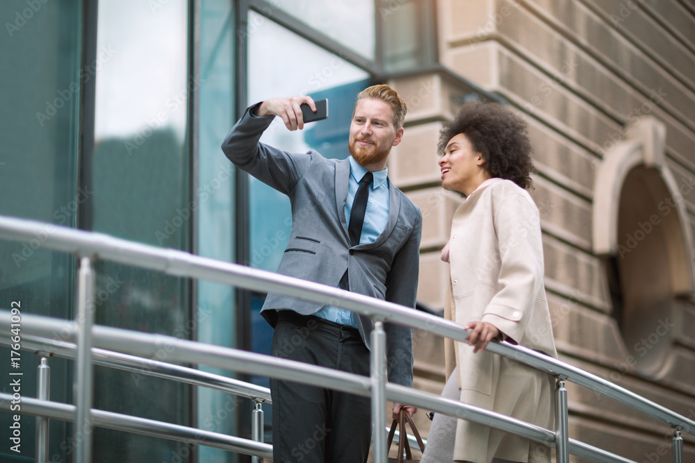 Happy business couple using smart phone outdoors Happy business couple using smart phone outdoors