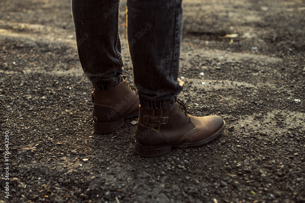 Mens boots on rocks in the autumn sunshine Mens boots on rocks in the autumn sunshine