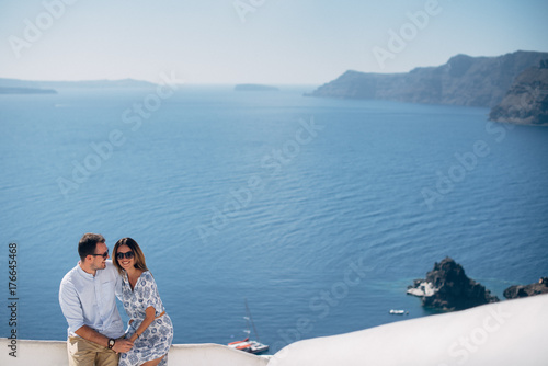 Happy couple hugging and laughing together with a view of Santorini © Vadim Pastuh