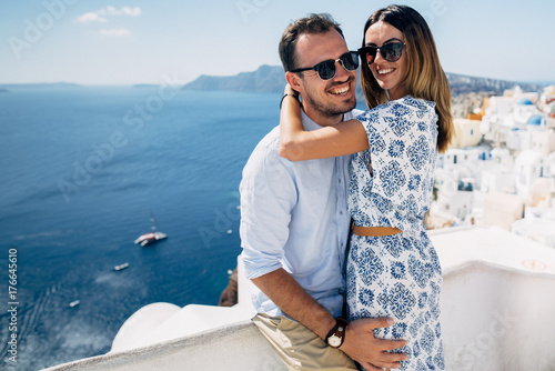 Happy couple hugging and laughing together with a view of Santorini © Vadim Pastuh