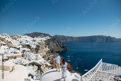 The couple is standing on the roof in Santorini