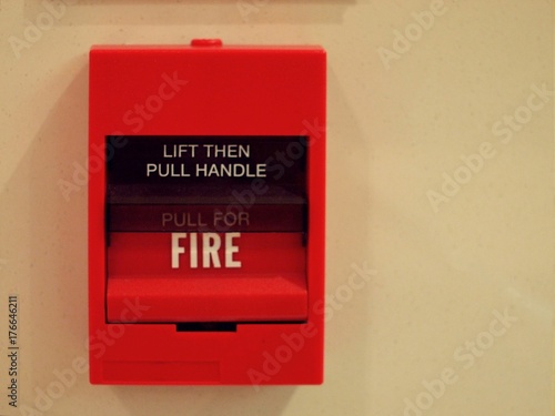 red square fire alarm box switch on cream wall 