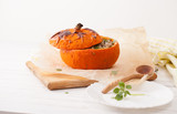 Baked pumpkin with a wooden spoon on the table