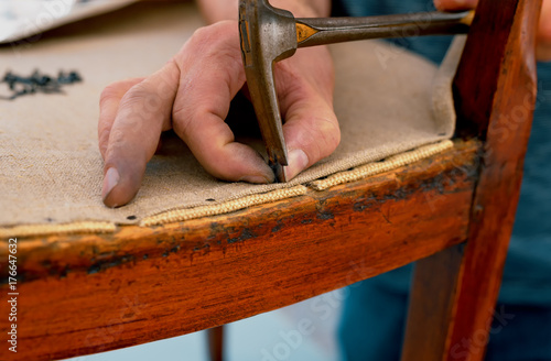 a upholsterer repairs an antique chair photo