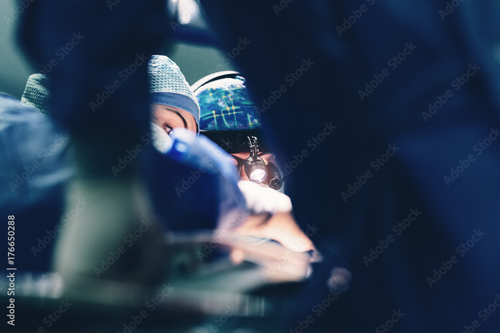 Surgeon doctor operating using special lamp lighting and glasses loupes