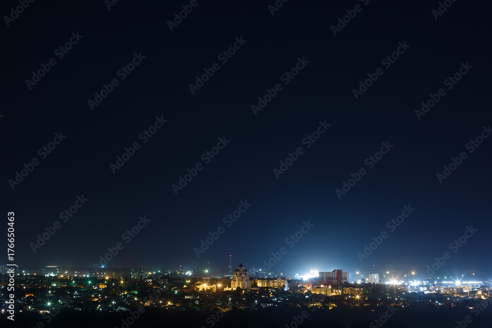 The bright lights of the city streets in the background of the night sky The bright lights of the city streets in the background of the night sky