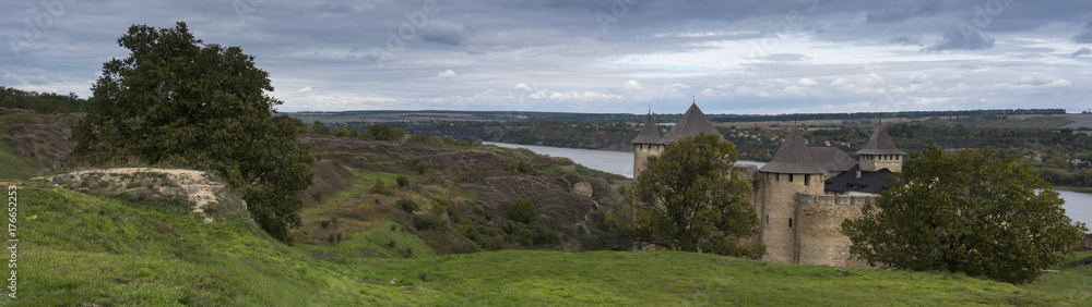 Panorama of medieval castle and lookout tower on beautiful shore of river