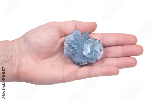 Woman's hand holding blue celestite cluster isolated on white background