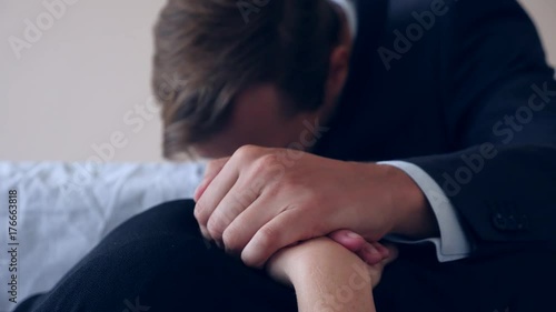 funeral, sadness and mourning concept - a sad man talking and crying next to the coffin. 4k,