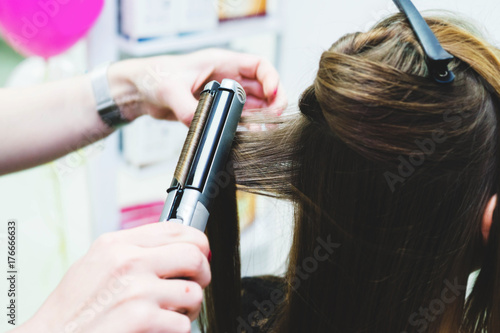 Woman hairdresser making hairstyle in barbershop