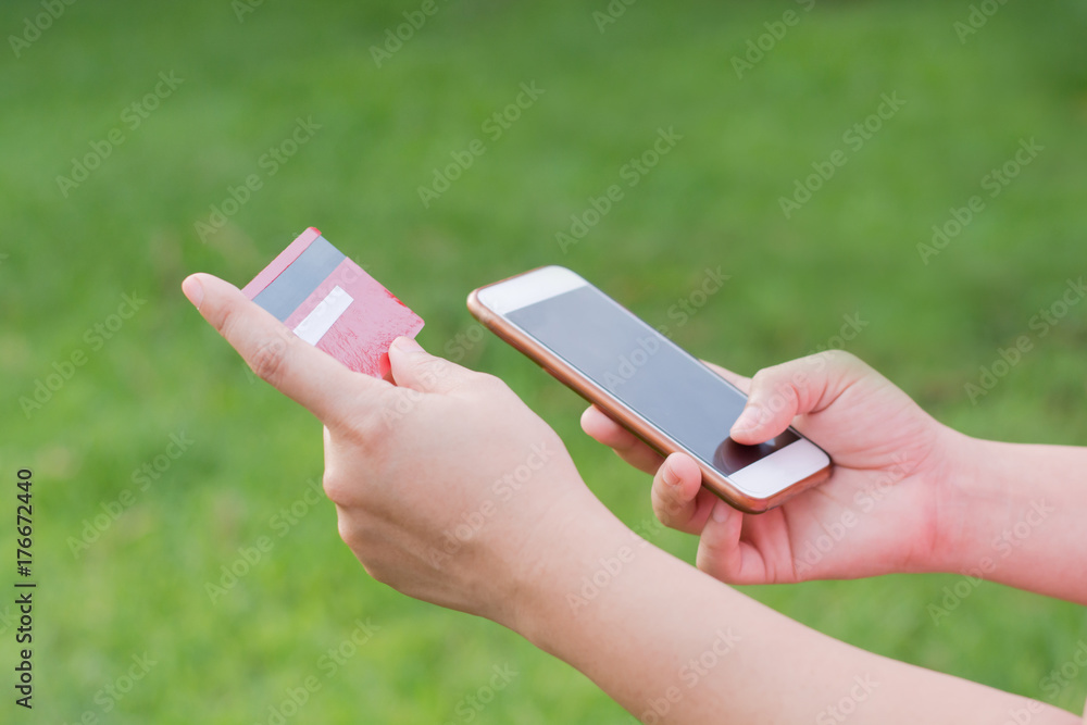 woman hands holding credit card and using cell, smart phone for online shopping