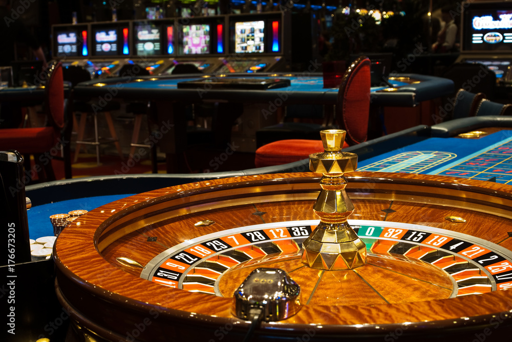 Golden Casino theme. High contrast image of casino roulette, poker game, dice game, poker chips on a gaming table. Golden Casino theme. High contrast image of casino roulette, poker game, dice game, poker chips on a gaming table.