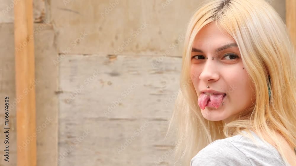 bodymification. a girl with a split tongue turns to the camera ...