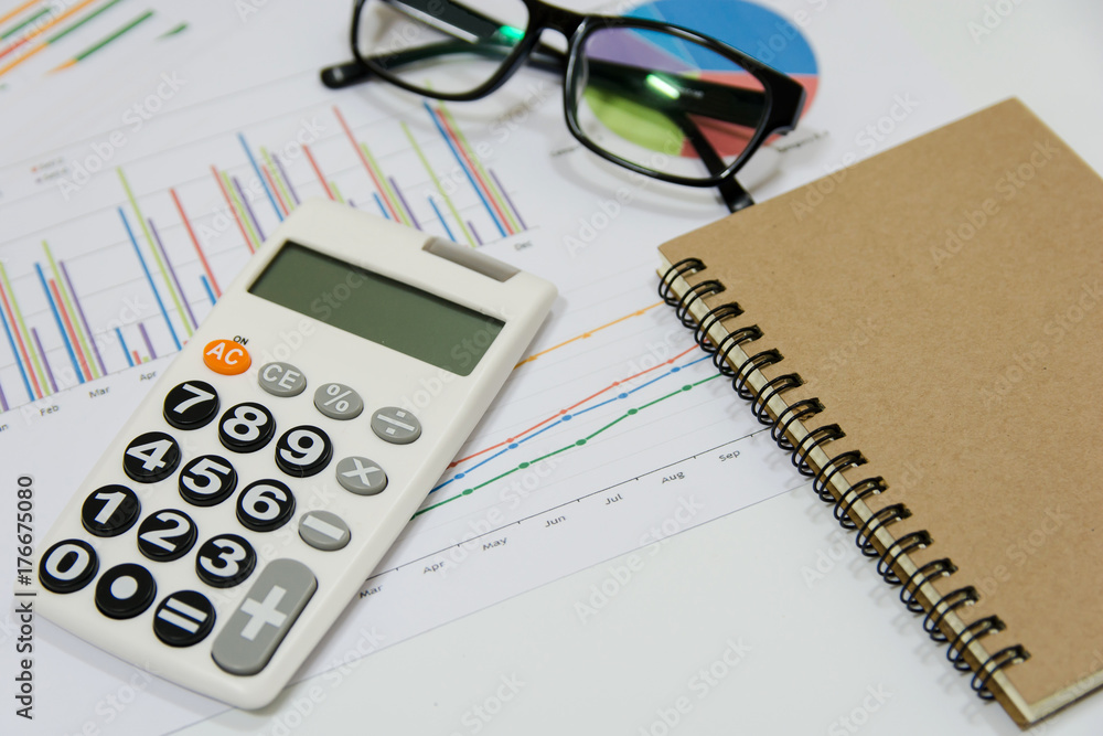 Office Concepts : data analyzing with calculator,glasses,notebook and pen. on charts and graph to find out the result. Office Concepts : data analyzing with calculator,glasses,notebook and pen. on charts and graph to find out the result.