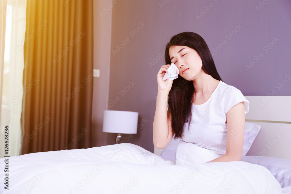 woman is crying on bed in bedroom woman is crying on bed in bedroom
