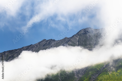 A beautiful mountain landscape with mountain tops above the clouds.