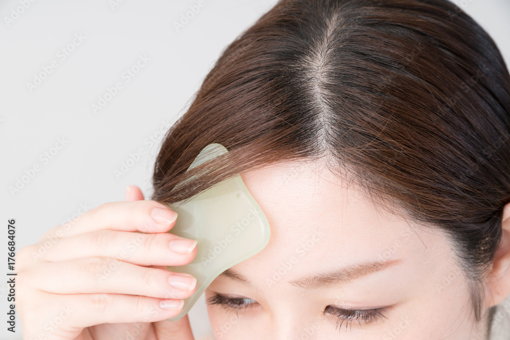 Naklejka premium セルフマッサージをする女性、かっさ、顔