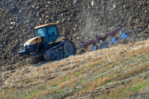 Tractor plowing a hilly field