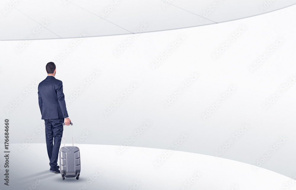 Businessman with suitcase walking in waiting room Businessman with suitcase walking in waiting room