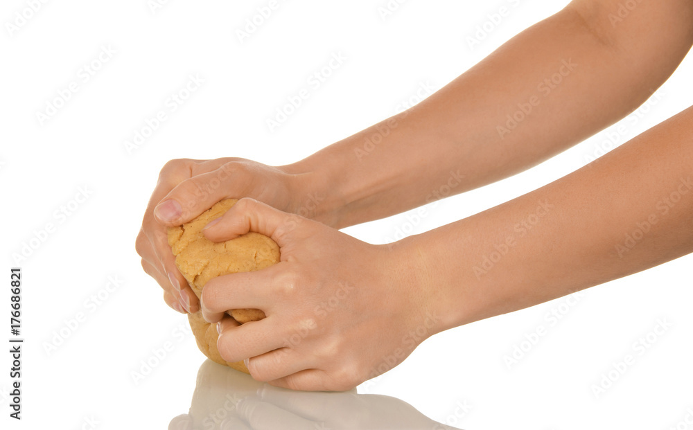 Female hands kneading piece of dough, isolated on white background Female hands kneading piece of dough, isolated on white background