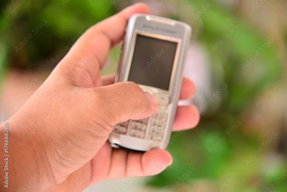 Close up hand on blurred small mobile.Selective focus at hand on. Close up hand on blurred small mobile.Selective focus at hand on.