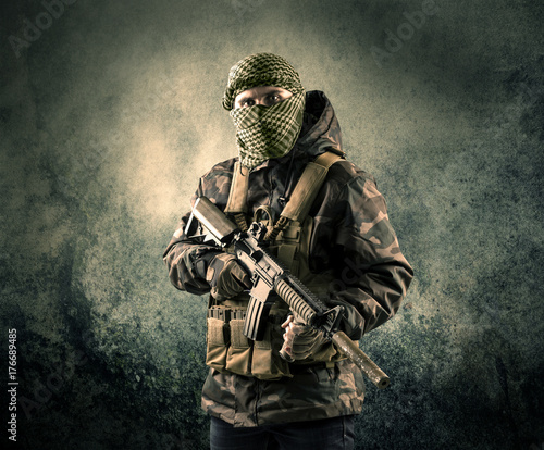 Foto Portrait of a heavily armed masked soldier with grungy background