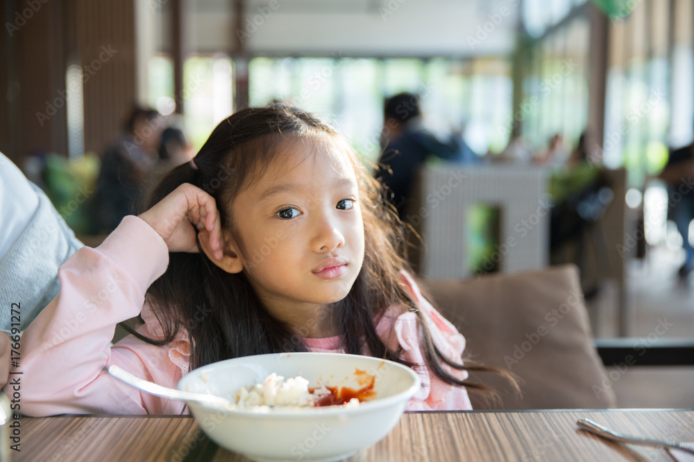 Little asian girl feeling bore the food with the rice and tomato sauce Little asian girl feeling bore the food with the rice and tomato sauce