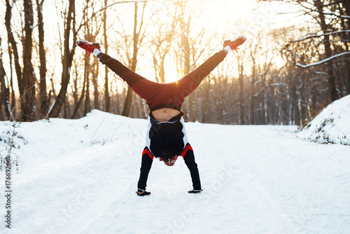 Inspired sportsman doing handstand while warming up before hard training