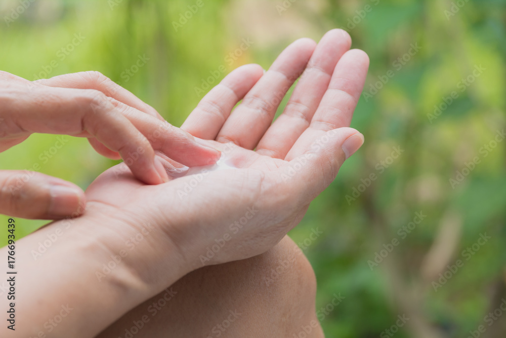 hand of woman apply lotion on skin of hand on nature table. hand of woman apply lotion on skin of hand on nature table.