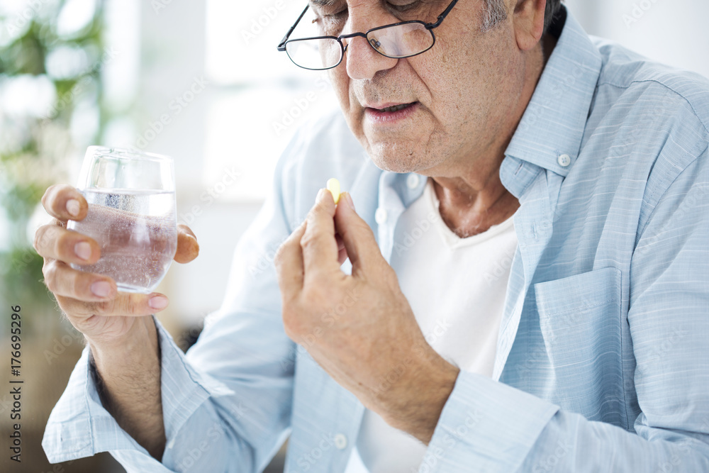 Old man taking a pill Old man taking a pill