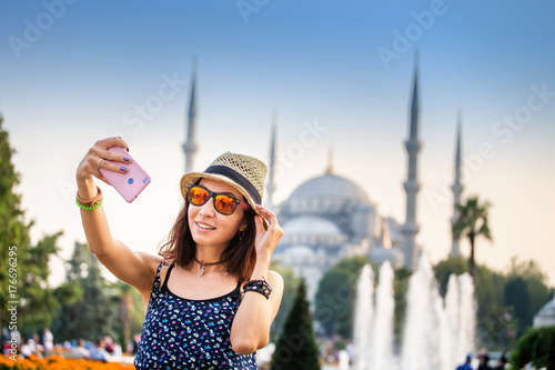 Photography Happy woman in hat and sunglasses making selfie by the smartphone on the backgro