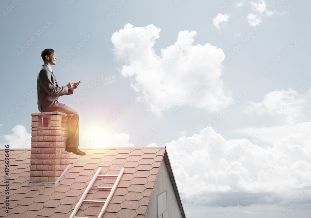 Student guy in suit on brick house roof reading book Student guy in suit on brick house roof reading book