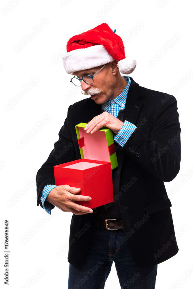 Vertical shot of a surprised senior opening a Christmas present isolated on white Vertical shot of a surprised senior opening a Christmas present isolated on white