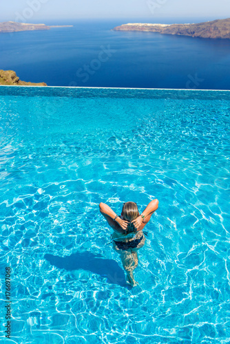 Woman enjoying relaxation in pool and looking at the view