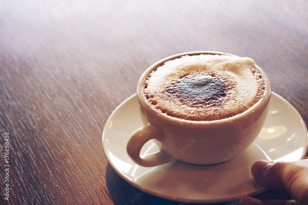 serve fresh hot cappuccino coffee in white cup on wood table in the morning for breakfast drink before work on warm white and nature light at cafe restaurant or office on vintage blue style serve fresh hot cappuccino coffee in white cup on wood table in the morning for breakfast drink before work on warm white and nature light at cafe restaurant or office on vintage blue style
