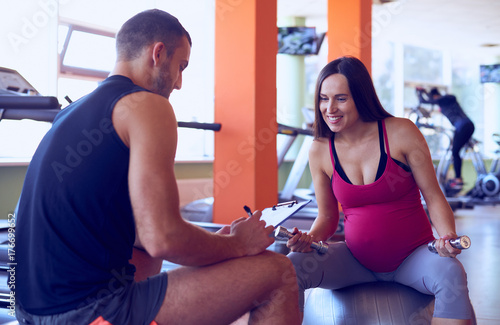 Pregnant woman talking with personal trainer