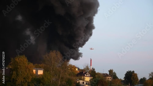 The helicopter flew into the smoke and was able to from a fire. A violent fire in the city. The salvation salvage extinguishes the fire from the helicopter. MOE .Fire and flame. Ecological catastrophy photo