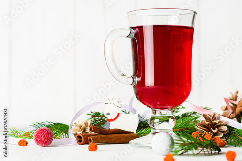 A glass of red hot mulled wine on a light background. Christmas and New Year greeting card.