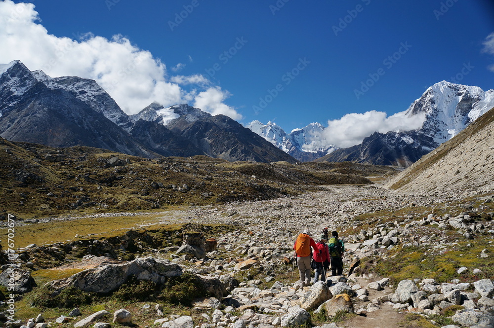 Туристы идут по каменистой тропе на фоне Гималайских гор.