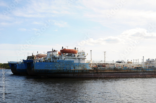 The old barge ship is anchored at an abandoned shipyard, in the harbor