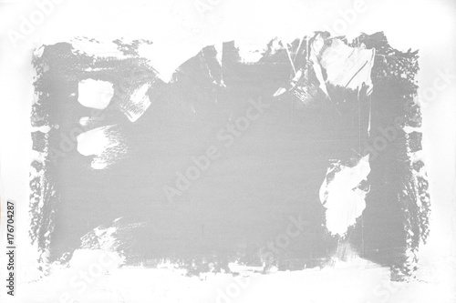 Brushstrokes of white paint covering the grey concrete wall. Abstract background with place for inscription.