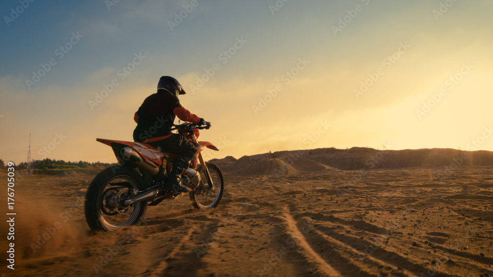 Shot of the Professional Motocross Driver Riding on His FMX Motorcycle on the Extreme Off-Road Terrain Track. Shot of the Professional Motocross Driver Riding on His FMX Motorcycle on the Extreme Off-Road Terrain Track.