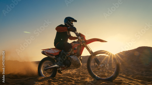 Low Angle Shot of the Professional Motocross Driver Riding on His FMX Motorcycle on the Extreme Off-Road Terrain Track.