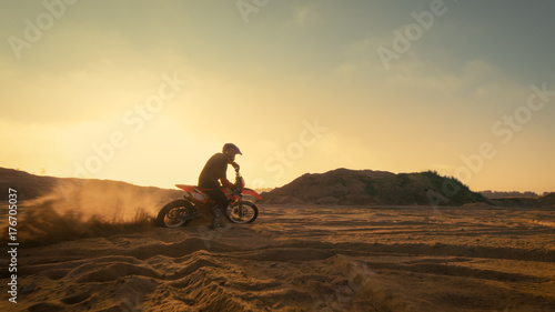 Shot of the Professional Motocross Driver Turning on His FMX Motorcycle on the Extreme Off-Road Terrain Track.