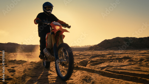 Following Shot of the Professional Motocross Driver Riding on His FMX Motorcycle on the Extreme Off-Road Terrain Track.